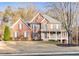 Charming brick two-story home boasts a manicured lawn and inviting front porch at 4330 Old Oak Trce, Cumming, GA 30041