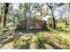 View of the back of the home, showing the brick exterior and backyard with mature trees at 4479 Richard Rd, Conley, GA 30288