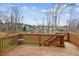 Wooden back deck overlooking a wooded lot with fenced in yard and featuring a small outdoor table at 6350 Boulder Rdg, Cumming, GA 30028
