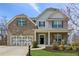Beautiful two-story home boasting a brick facade, inviting front porch, and meticulously landscaped front yard at 6350 Boulder Rdg, Cumming, GA 30028