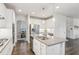 Bright kitchen features white cabinets, stainless steel appliances, granite countertops, and a view into the adjacent dining room at 6350 Boulder Rdg, Cumming, GA 30028