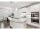 Bright kitchen features white cabinets, stainless steel appliances, granite countertops, and a view into the breakfast room at 6350 Boulder Rdg, Cumming, GA 30028