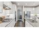 Bright kitchen features white cabinets, stainless steel appliances, granite countertops, and a view into the adjacent dining room at 6350 Boulder Rdg, Cumming, GA 30028
