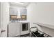 Laundry room with front loading machines, gray cabinets, and a folding station at 6350 Boulder Rdg, Cumming, GA 30028