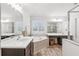 Bright bathroom featuring a large soaking tub, glass shower, dual sink vanities, and shuttered windows at 6350 Boulder Rdg, Cumming, GA 30028
