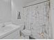 Bathroom features a vanity, toilet, and shower with a patterned curtain at 7013 Mahonia Pl, Lithonia, GA 30038