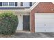 Close-up of the front entrance and garage showcasing the brick accent and security features at 7013 Mahonia Pl, Lithonia, GA 30038
