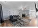Spacious living room with dark wood floors, a fireplace, and a modern ceiling fan at 7013 Mahonia Pl, Lithonia, GA 30038
