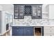 Modern home bar with blue cabinets, wine rack, beverage cooler, and marble countertops at 2387 Battle Dr, Villa Rica, GA 30180