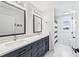 Elegant bathroom showcasing a double vanity with navy cabinets, marble floors, and modern lighting at 2387 Battle Dr, Villa Rica, GA 30180