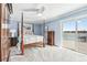 Comfortable bedroom with lake view, featuring a four-poster bed, ceiling fan, and sliding glass doors at 2387 Battle Dr, Villa Rica, GA 30180