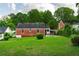 Spacious backyard with lush green lawn, mature trees, and charming brick home in view at 2656 Northview Ave, Decatur, GA 30032