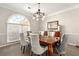 Formal dining room with a modern chandelier, large window, and elegant furnishings at 4184 Wyndham Park Cir, Decatur, GA 30034