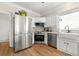 Well-lit kitchen features stainless steel appliances, white cabinetry, wood flooring and modern sink at 4184 Wyndham Park Cir, Decatur, GA 30034