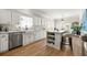 Open kitchen features an island with seating, white cabinetry, stainless steel appliances and wood flooring at 4184 Wyndham Park Cir, Decatur, GA 30034