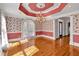 Bright dining room with hardwood floors, chandelier, floral wallpaper, and arched window at 300 Mill Creek Ct, Acworth, GA 30101
