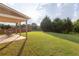 View of a well-maintained backyard with a covered patio, lawn, and privacy fence at 4162 Roberts Crest Dr, Suwanee, GA 30024