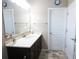 Bathroom with a dark vanity, light countertops, a large mirror, and tile floor at 4162 Roberts Crest Dr, Suwanee, GA 30024