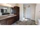 Elegant bathroom features double sinks, granite countertops, dark wood cabinetry, and walk-in shower at 4162 Roberts Crest Dr, Suwanee, GA 30024