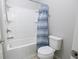 Bright bathroom features a shower-tub combo with a blue and white striped shower curtain and a toilet at 4162 Roberts Crest Dr, Suwanee, GA 30024