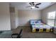 Neutral bedroom with a ceiling fan, a bed with colorful cover, and a desk at 4162 Roberts Crest Dr, Suwanee, GA 30024