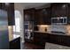 Well-appointed kitchen featuring granite countertops, stainless steel appliances, and dark wood cabinets and flooring at 4162 Roberts Crest Dr, Suwanee, GA 30024