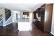 Open kitchen with stainless appliances, center island, dark hardwood floors, and staircase in background at 4162 Roberts Crest Dr, Suwanee, GA 30024