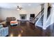 Spacious living room features a brick fireplace, staircase, hardwood floors, and plenty of seating at 4162 Roberts Crest Dr, Suwanee, GA 30024