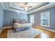 Bedroom showcasing tray ceiling, hardwood floors, ceiling fan, and ample natural light from the windows at 12 Candler Grove Dr, Decatur, GA 30030