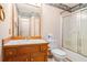 This bathroom has a wooden vanity with a large framed mirror and a tub/shower combo with sliding glass doors at 2033 Old Newnan Rd, Carrollton, GA 30116