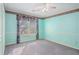 This quaint bedroom has colorful walls, chair rail and a lighted ceiling fan at 2033 Old Newnan Rd, Carrollton, GA 30116