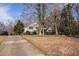 Quaint home with a long driveway, surrounded by mature trees, and a well-manicured lawn at 2033 Old Newnan Rd, Carrollton, GA 30116
