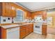 Classic kitchen featuring white appliances, wood cabinets, and checkered backsplash at 2033 Old Newnan Rd, Carrollton, GA 30116