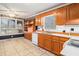 Traditional kitchen with light wood cabinets, white appliances, patterned tile flooring, and abundant natural light at 2033 Old Newnan Rd, Carrollton, GA 30116