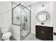 Modern bathroom with a glass-enclosed shower, round mirror, and marble-look tile at 4374 Westside Nw Dr, Acworth, GA 30101