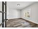 Bedroom with wood floors, white walls, a window with a view, and a black glass paneled door at 4374 Westside Nw Dr, Acworth, GA 30101