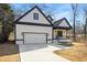 Stylish house featuring white vertical siding, dark trim, porch and large garage door at 4374 Westside Nw Dr, Acworth, GA 30101