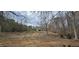 Sprawling backyard with mature trees, a barn and a pathway, offering space and serenity at 3640 Chandler Haulk Rd, Loganville, GA 30052