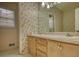 Bathroom with a double sink vanity, storage cabinets, and decorative wallpaper at 424 Cannonball Ct, Stockbridge, GA 30281