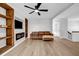 Spacious living room boasts modern flooring, a stylish ceiling fan, and custom built-in shelving surrounding a fireplace at 2390 Amberbrook Sw Dr, Conyers, GA 30094