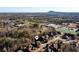 An aerial view shows a lovely home near a bustling neighborhood surrounded by trees at 5230 Harris Springs Dr, Cumming, GA 30040