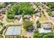 An aerial view showcasing the neighborhood, pool, and tennis courts surrounded by mature trees and lush landscaping at 5230 Harris Springs Dr, Cumming, GA 30040