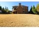A spacious backyard featuring a lush lawn and a charming screened porch on a brick home at 5230 Harris Springs Dr, Cumming, GA 30040