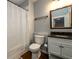 Well-lit bathroom features modern fixtures, a vanity with dark countertops, and a shower with a curtain at 5230 Harris Springs Dr, Cumming, GA 30040