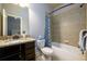 Well-lit bathroom featuring a combination tub and shower, dark vanity, and neutral color scheme at 5230 Harris Springs Dr, Cumming, GA 30040