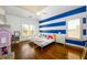 Charming bedroom featuring twin beds, hardwood floors and white and blue painted accent wall at 5230 Harris Springs Dr, Cumming, GA 30040