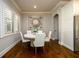 Sunlit dining area with hardwood floors, plantation shutters, and a modern chandelier at 5230 Harris Springs Dr, Cumming, GA 30040