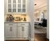 Butler's pantry with an espresso machine leads into a dining room with modern lighting and a gray rug at 5230 Harris Springs Dr, Cumming, GA 30040
