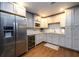 Stylish kitchen with stainless steel appliances, light gray cabinets, and tiled backsplash, perfect for cooking at 5230 Harris Springs Dr, Cumming, GA 30040