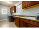 Functional laundry room features a sink, counter, and ample wood cabinet space for storage and organization at 5230 Harris Springs Dr, Cumming, GA 30040